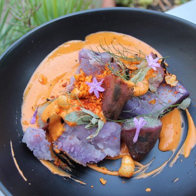 Close up of a plate containing Indigenous food coloured orange and purple